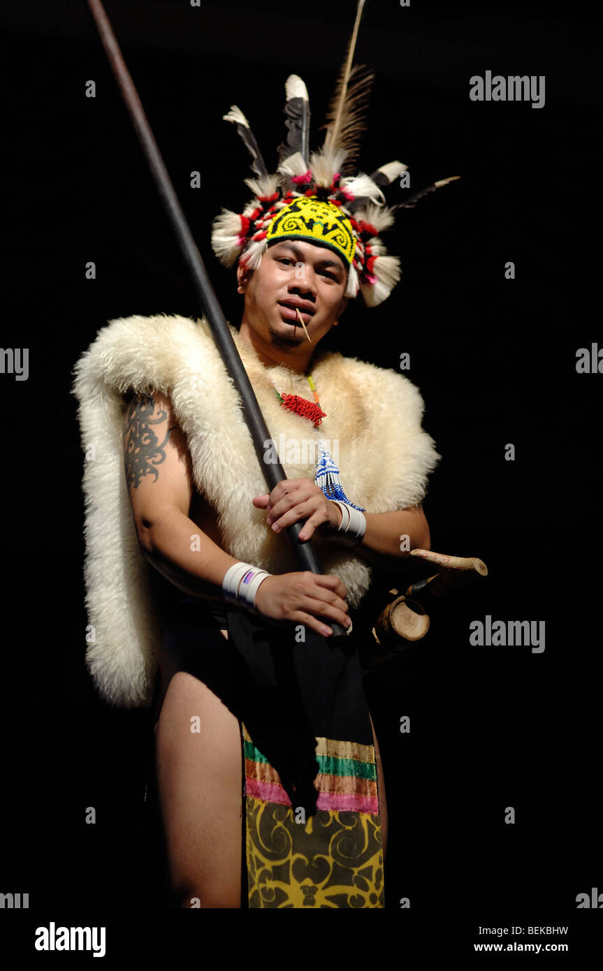 Guerrier de la tribu Orang Ulu ou Dayak en tête à plumes, vêtements ethniques et peaux d'animaux avec Blowpipe Dance Sarawak Malaysia Bornéo Banque D'Images