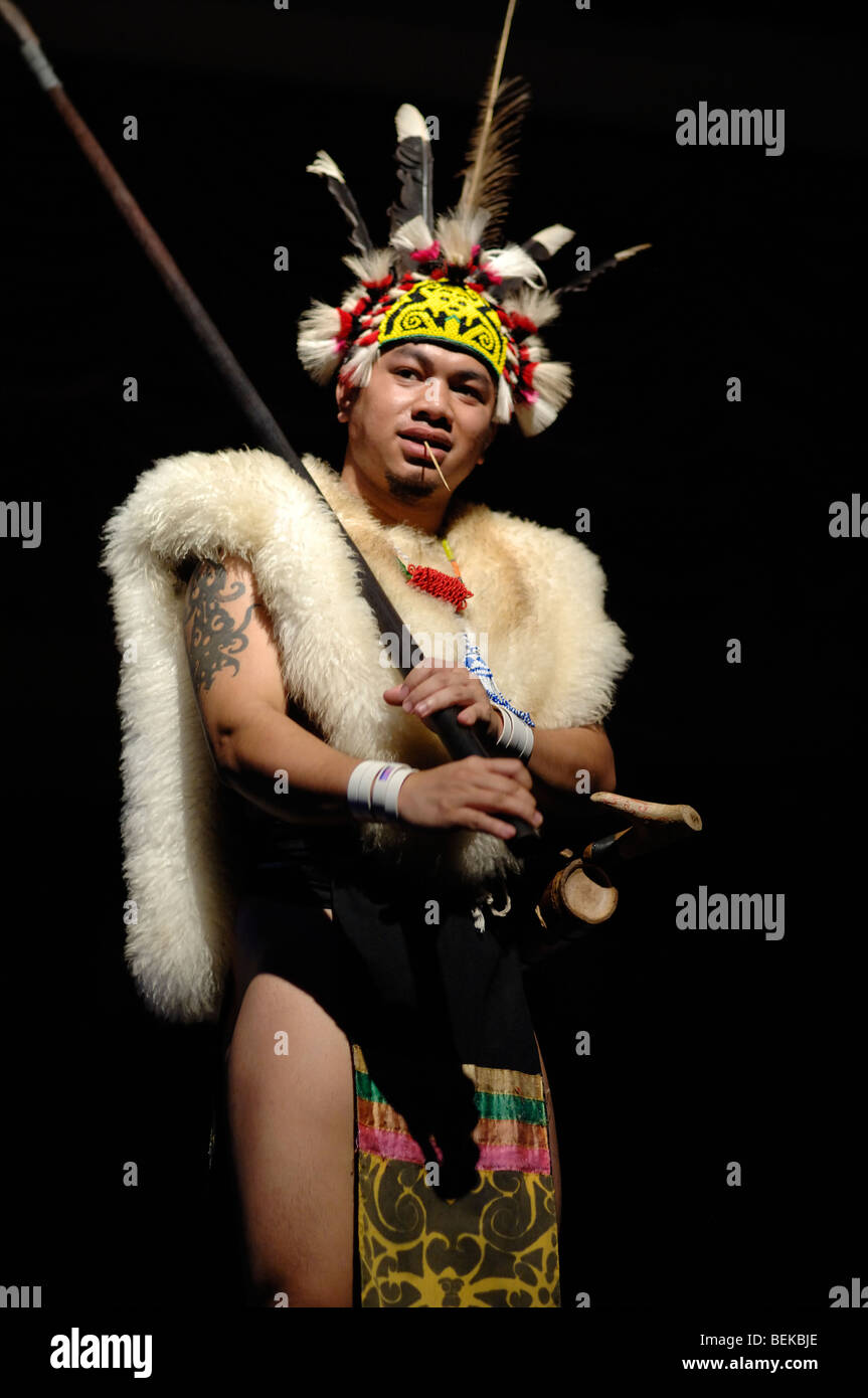 Guerrier de la tribu Orang Ulu ou Dayak en tête à plumes, vêtements ethniques et peaux d'animaux avec Blowpipe Dance Sarawak Malaysia Bornéo Banque D'Images