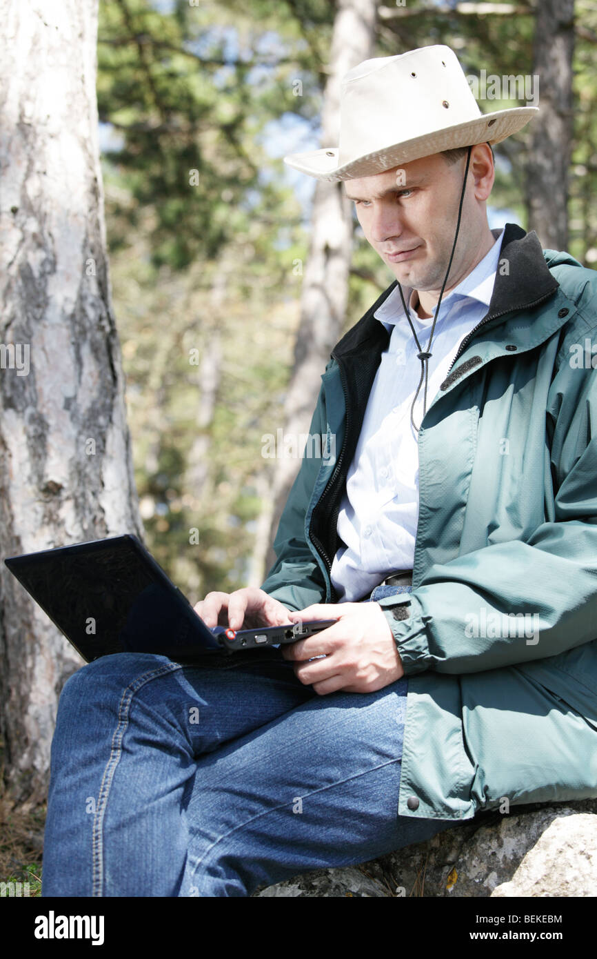 Homme avec portable dans la forêt Banque D'Images