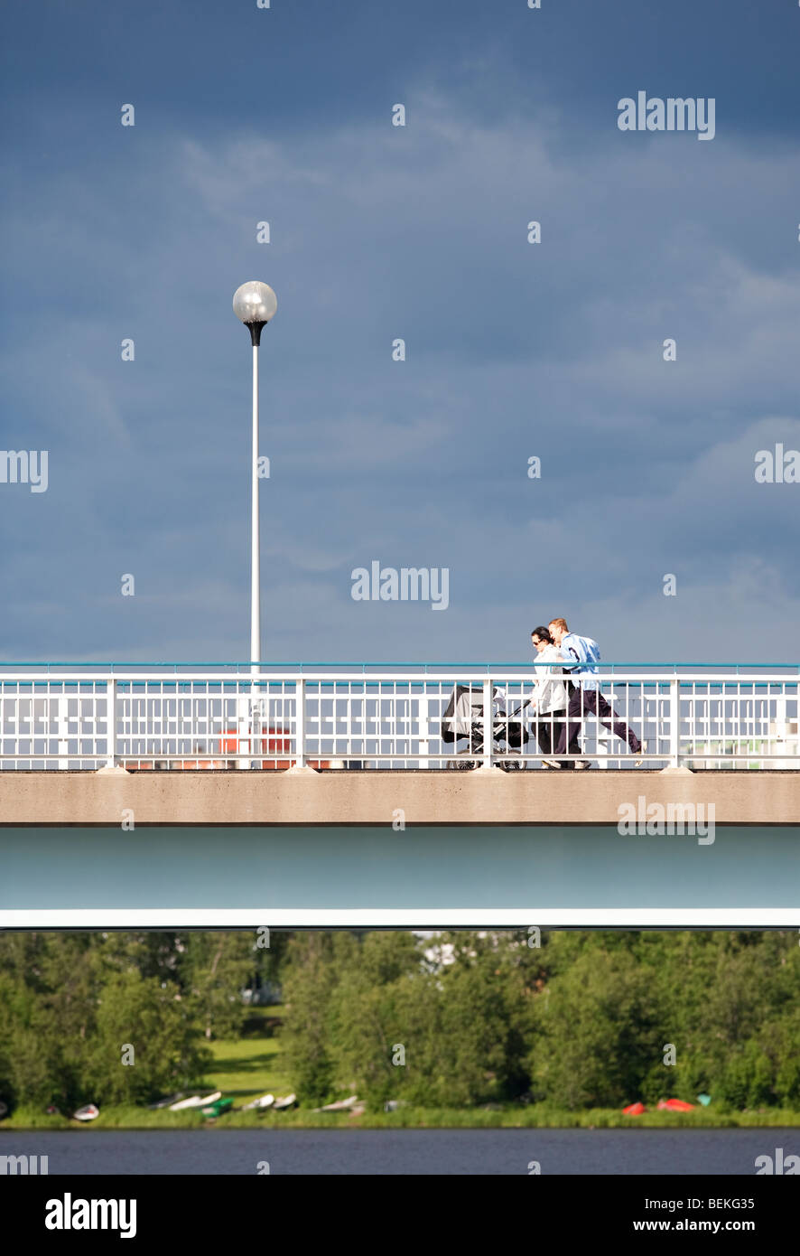 Un couple de traverser un pont avec la pram , Finlande Banque D'Images