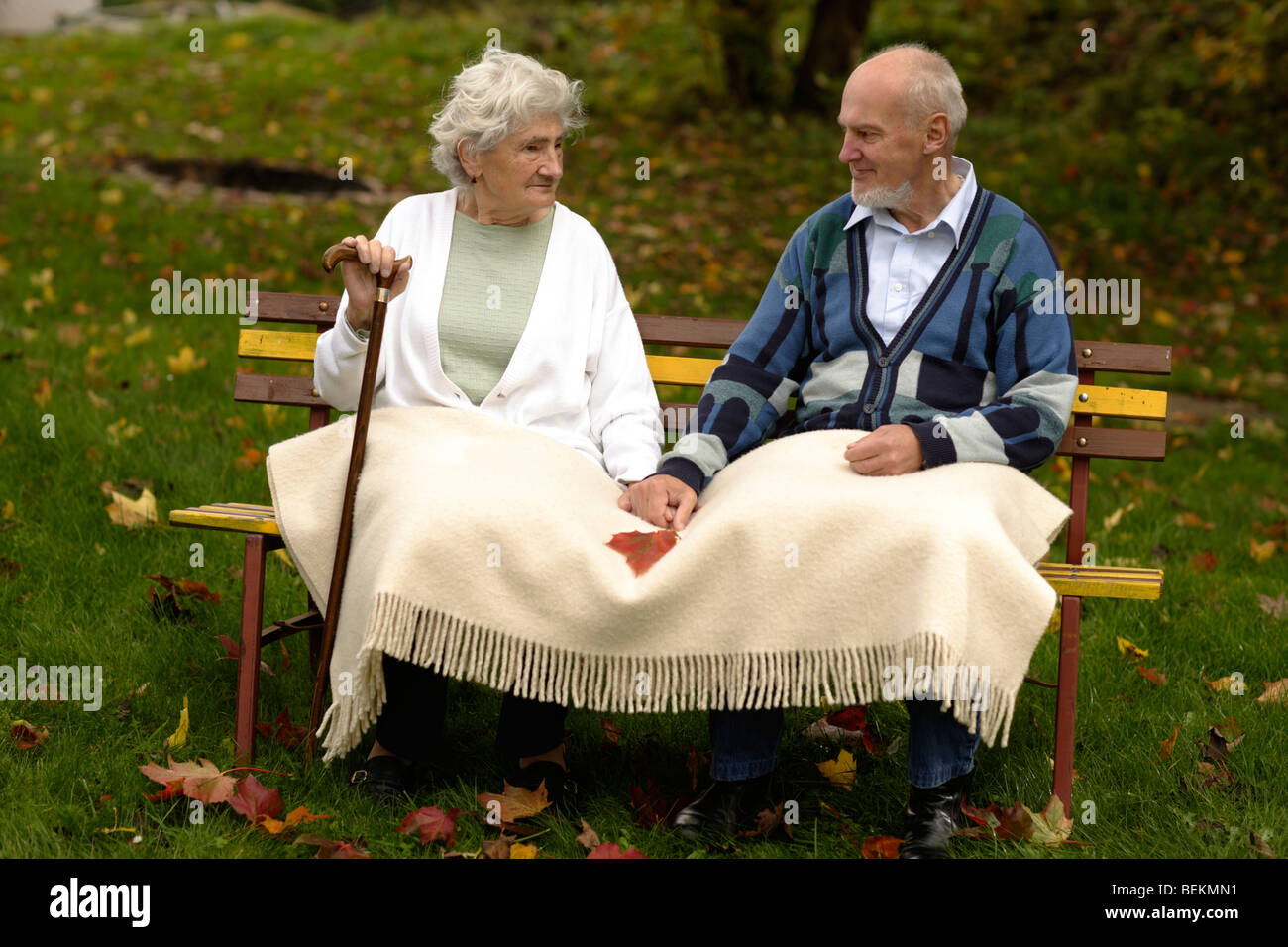 Couple de personnes âgées assis sur un siège en bois Banque D'Images