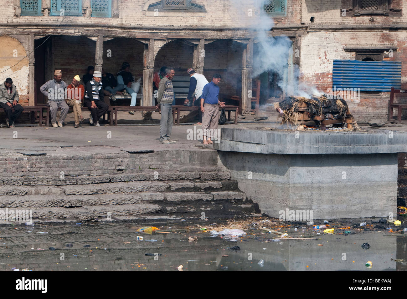 Pashupatinath, Népal. Un membre de la famille supervise une crémation sur un Ghat sur les rives de la rivière Bagmati. Banque D'Images