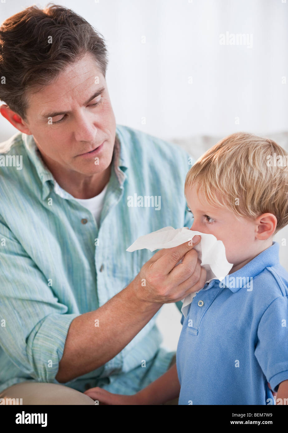 L'essuyant le nez de l'enfant père Banque D'Images