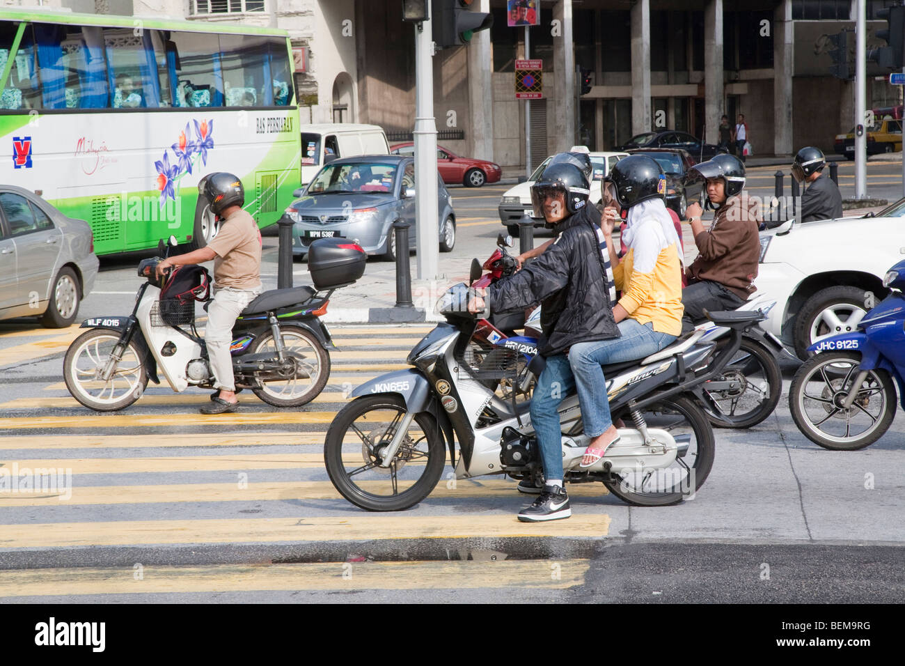 Cyclomoteurs et motocycles à l'intersection. Ces véhicules sont une forme courante de transport en Malaisie. Banque D'Images Cyclomoteurs et motocycles à l'intersection. Ces véhicules sont une forme courante de transport en Malaisie. Banque D'Images