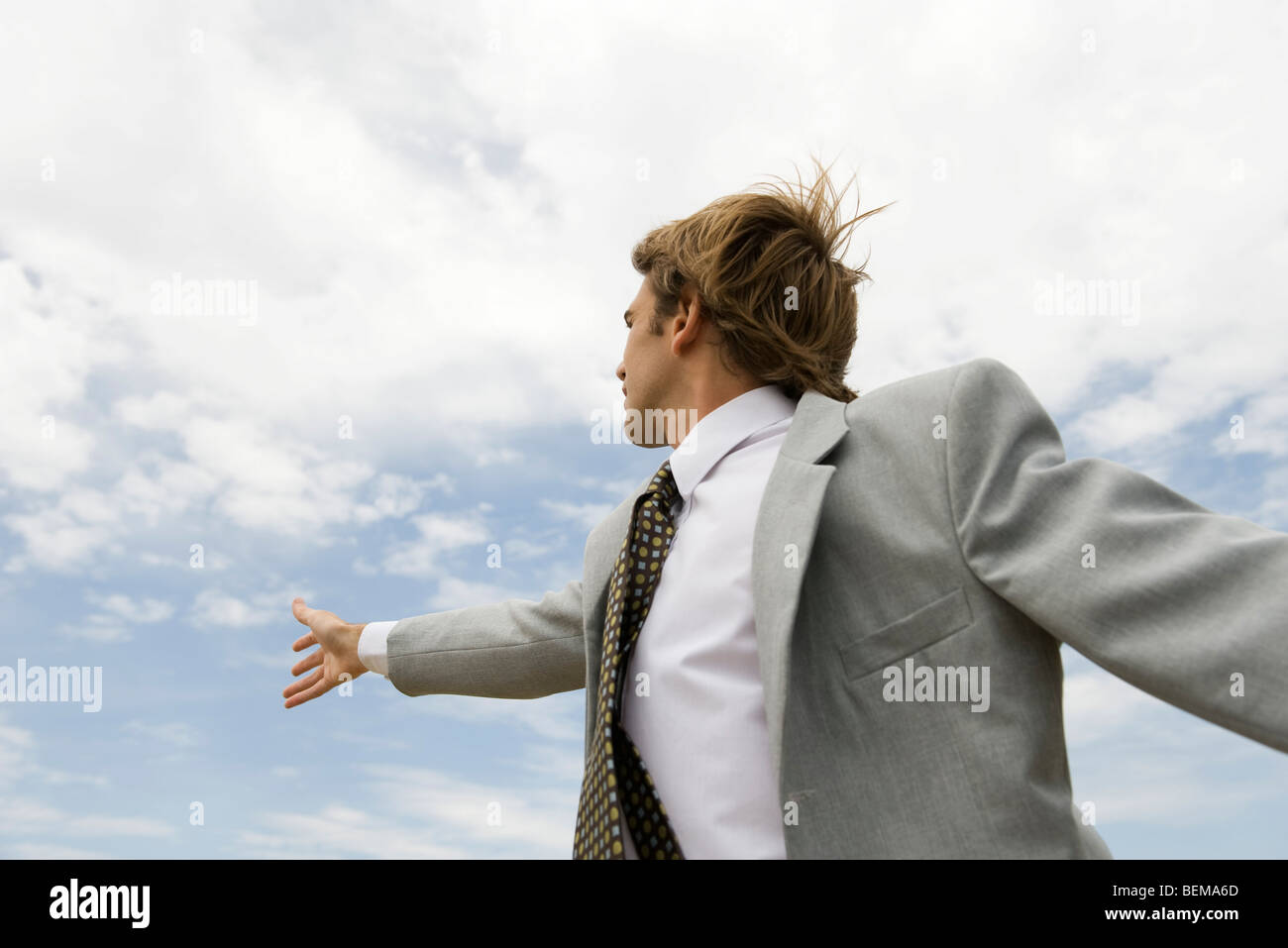 Businessman reaching vers sky Banque D'Images