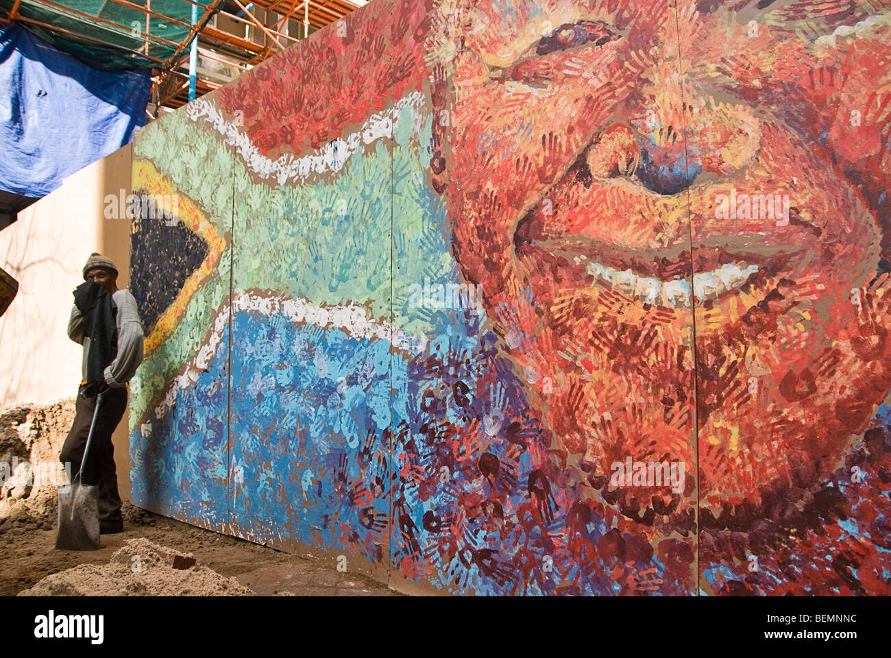 L'homme travaillant à côté une photo de Nelson Mandela et l'flagl sud-africain. Cape Town, Afrique du Sud, l'Afrique. Banque D'Images