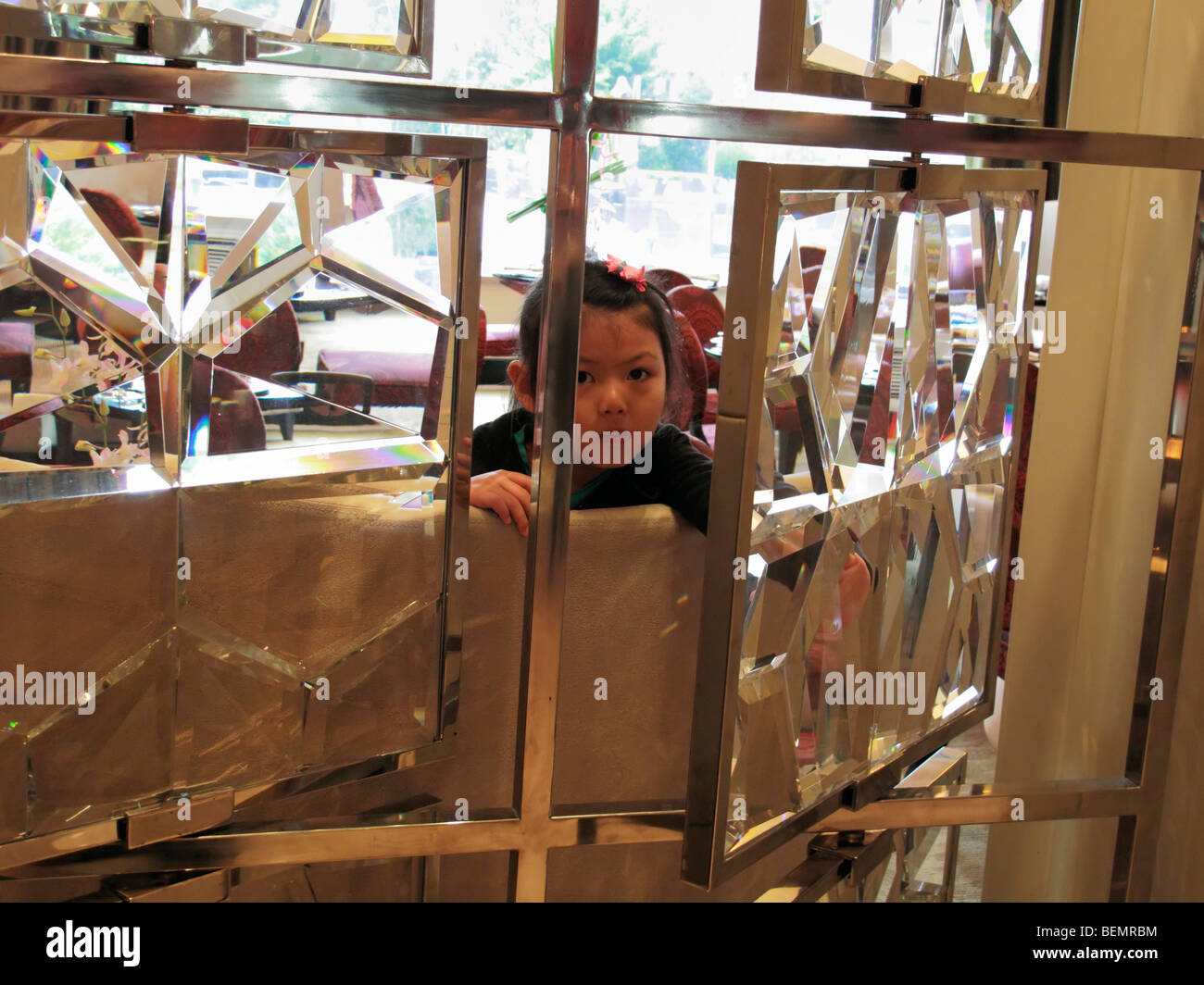 Une jeune fille chinoise parcourant une cloison de verre mur, Beijing CN Banque D'Images