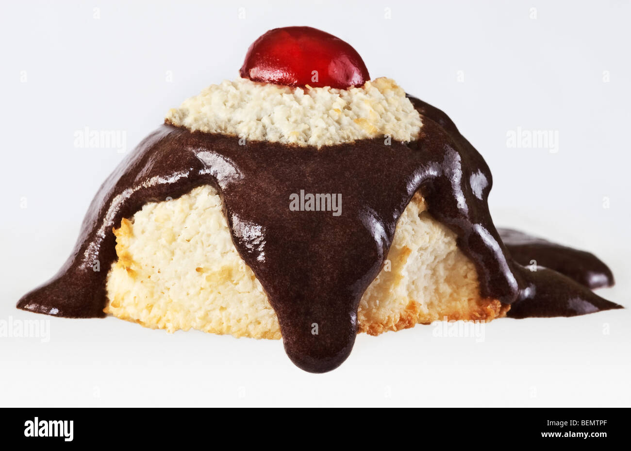 Petit gâteau de noix de coco garnie de sauce au chocolat qui coule Banque D'Images