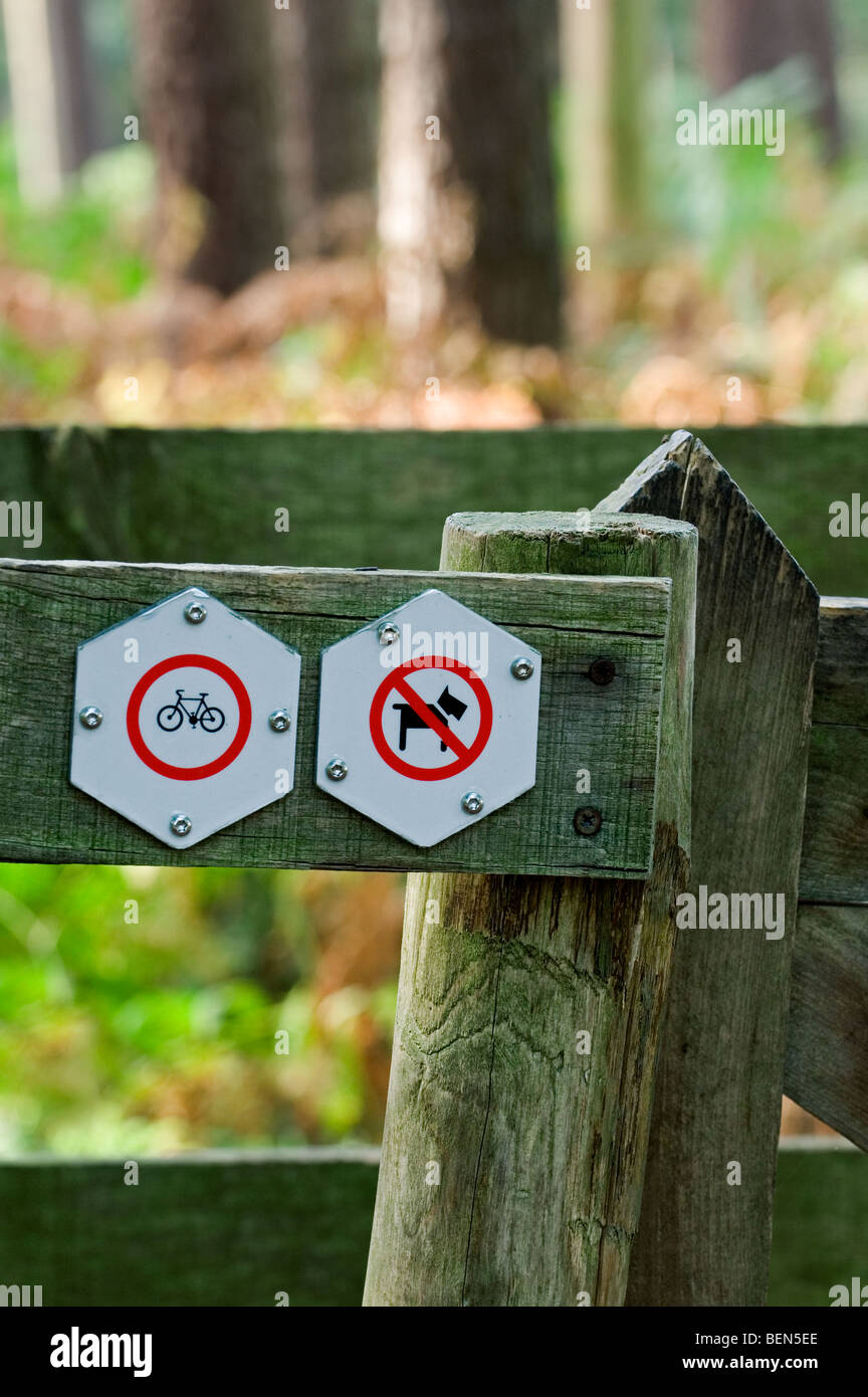 Les panneaux d'interdiction sur la barrière en bois à l'entrée de la réserve naturelle d'interdire l'accès pour les chiens et les vélos Banque D'Images