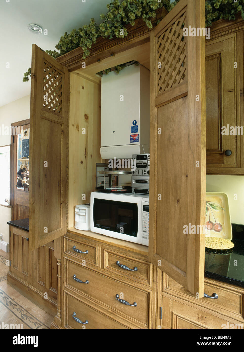 Armoire de cuisine en chêne avec portes ouvertes pour montrer au-dessus de  la chaudière de chauffage central à micro-ondes et d'un petit appareil  hi-fi Photo Stock - Alamy