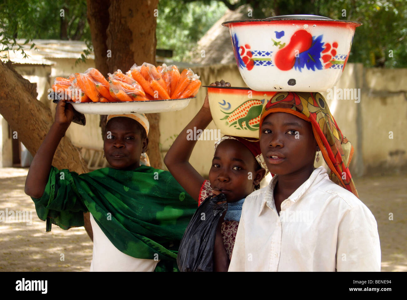 Noir africain autochtones exerçant son activité sous bassins avec des marchandises sur leurs têtes dans la rue de Maroua, Cameroun, Afrique Centrale Banque D'Images