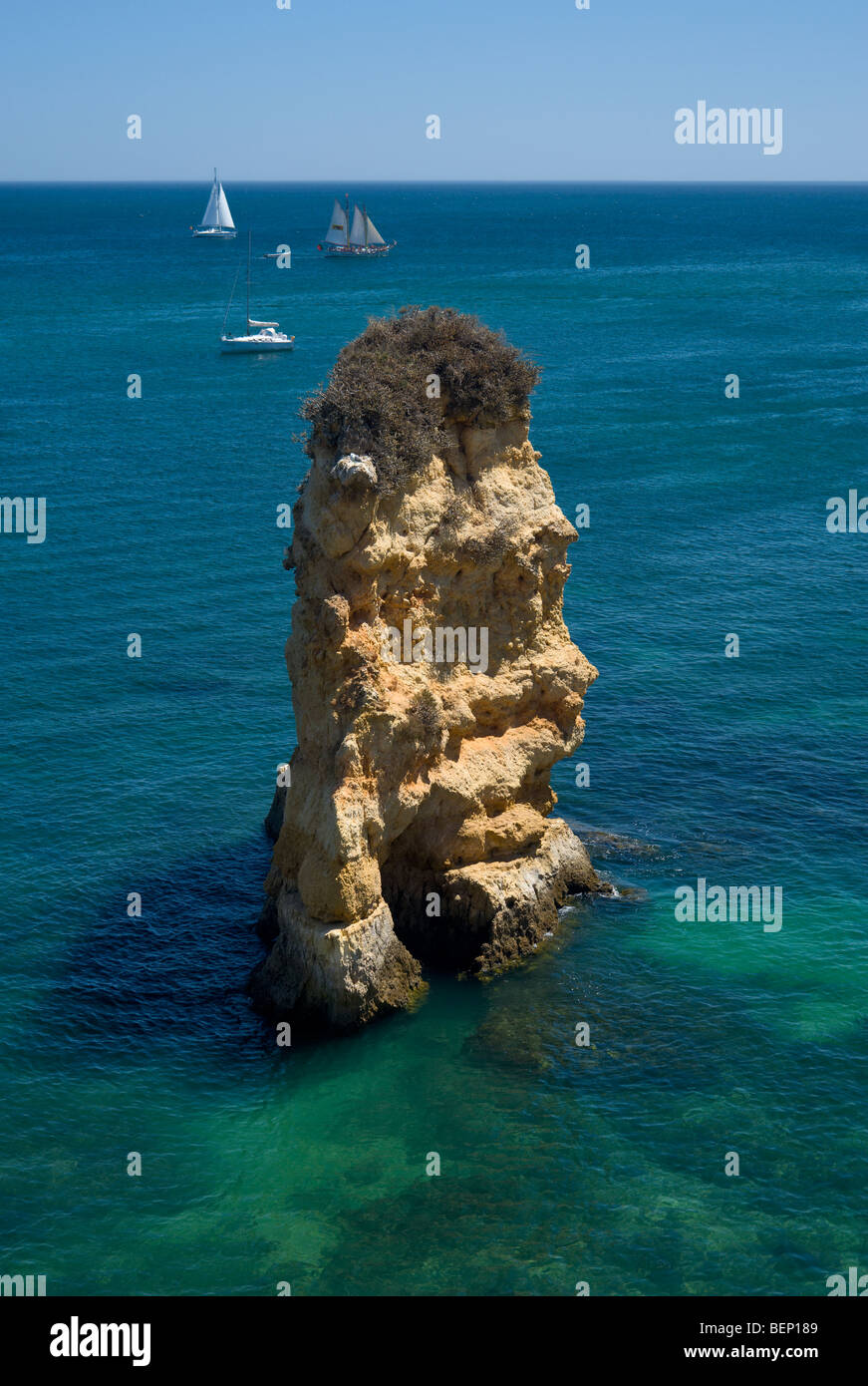 Le Portugal, l'Algarve, Lagos, Praia de Dona Ana, rock formation à distance avec des bateaux Banque D'Images