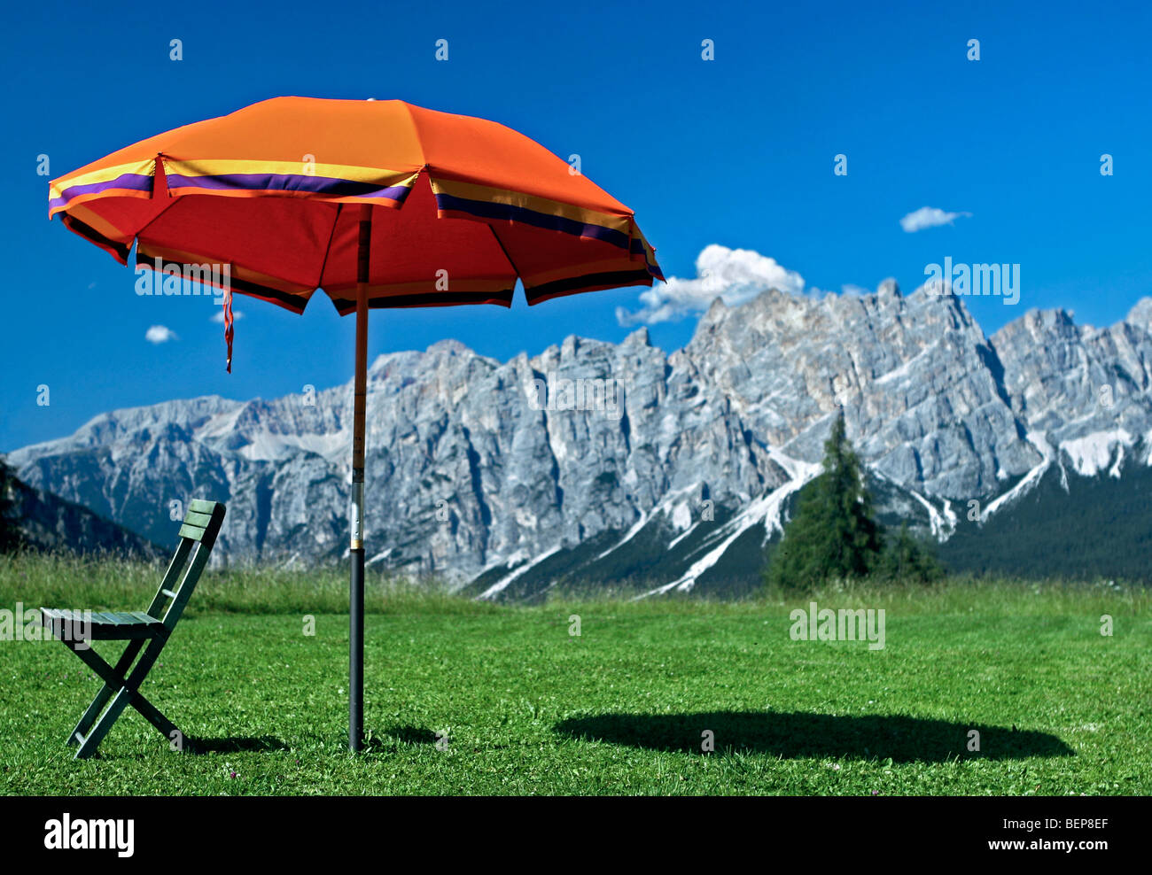 Orange parasol et chaise avec vue sur les montagnes, à Cortina d'Ampezzo, Dolomites, Italie Banque D'Images