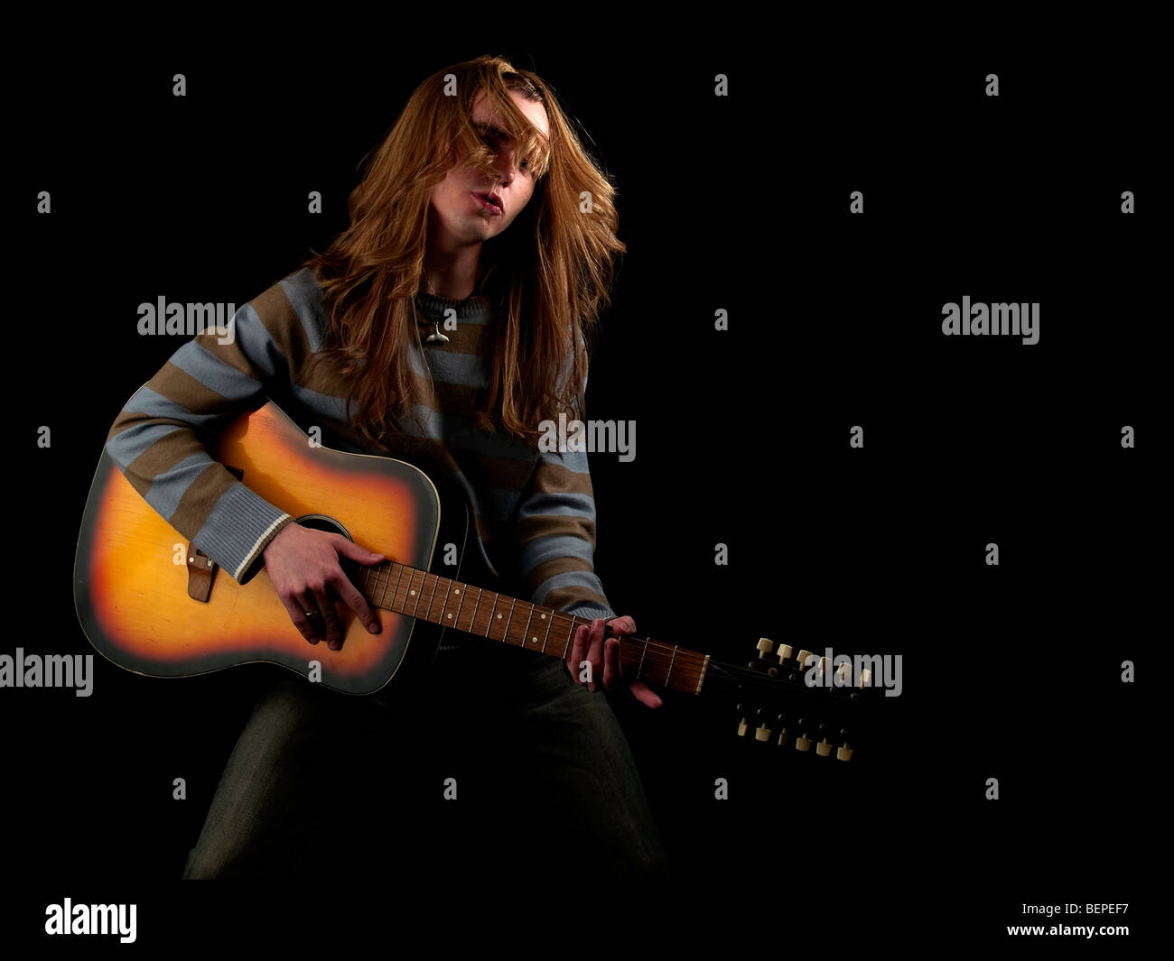Les jeunes cheveux longs joue le guitariste hard rock Banque D'Images