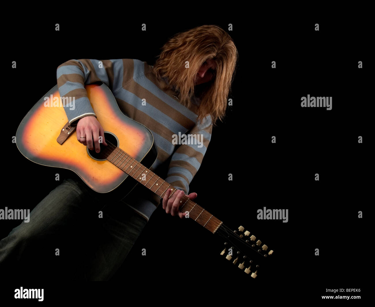 Les jeunes cheveux longs joue le guitariste hard rock Banque D'Images