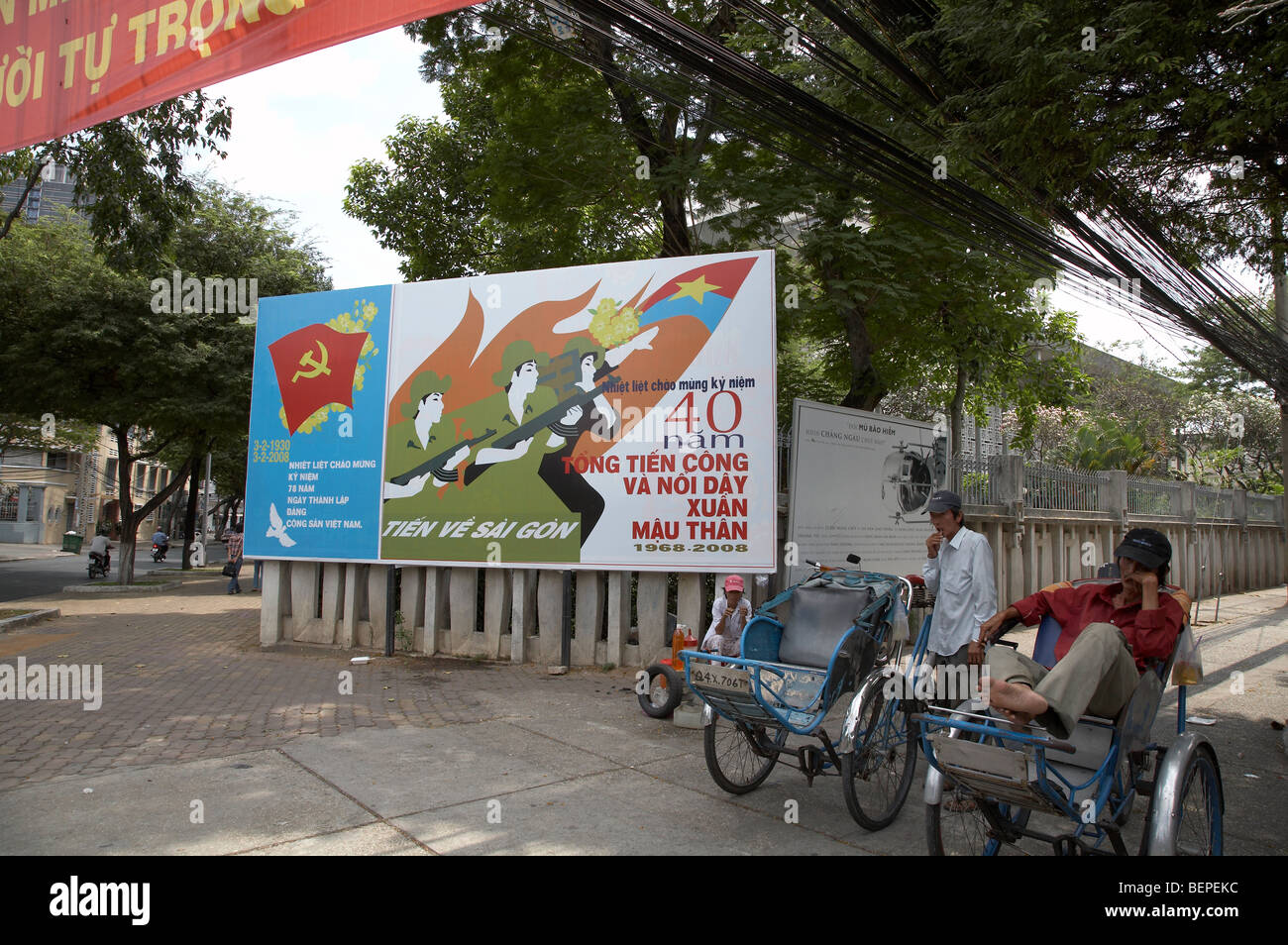 VIETNAM Cyclo à côté de pilotes affiche célébrant 40 ans depuis la victoire dans la guerre contre l'Amérique. photo par Sean SPRAGUE Banque D'Images