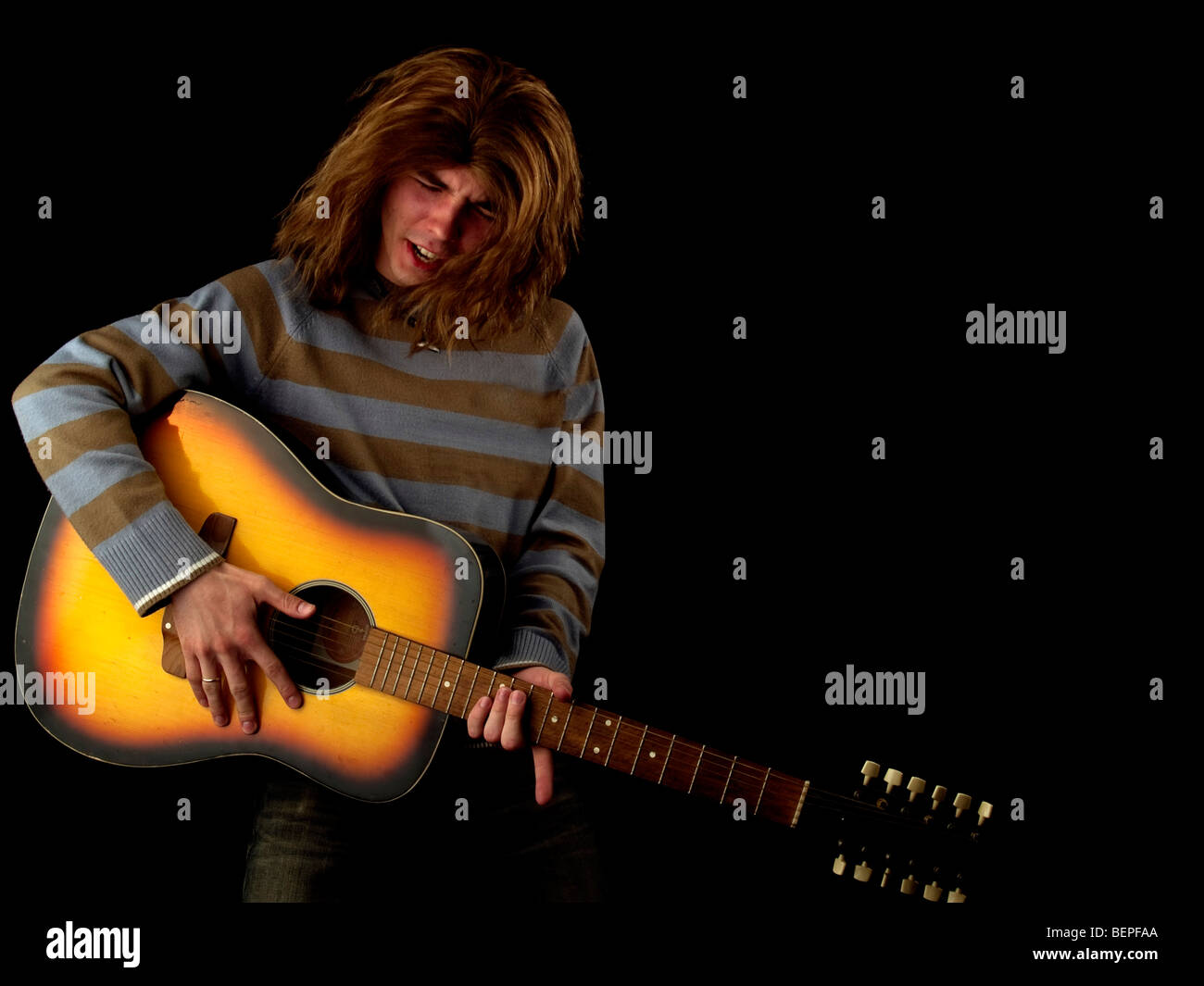 Les jeunes cheveux longs joue le guitariste hard rock Banque D'Images