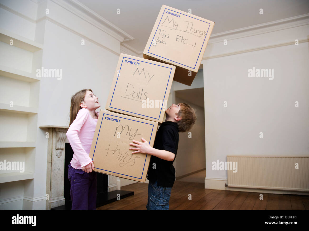 Deux enfants tenant une pile de boîtes Banque D'Images