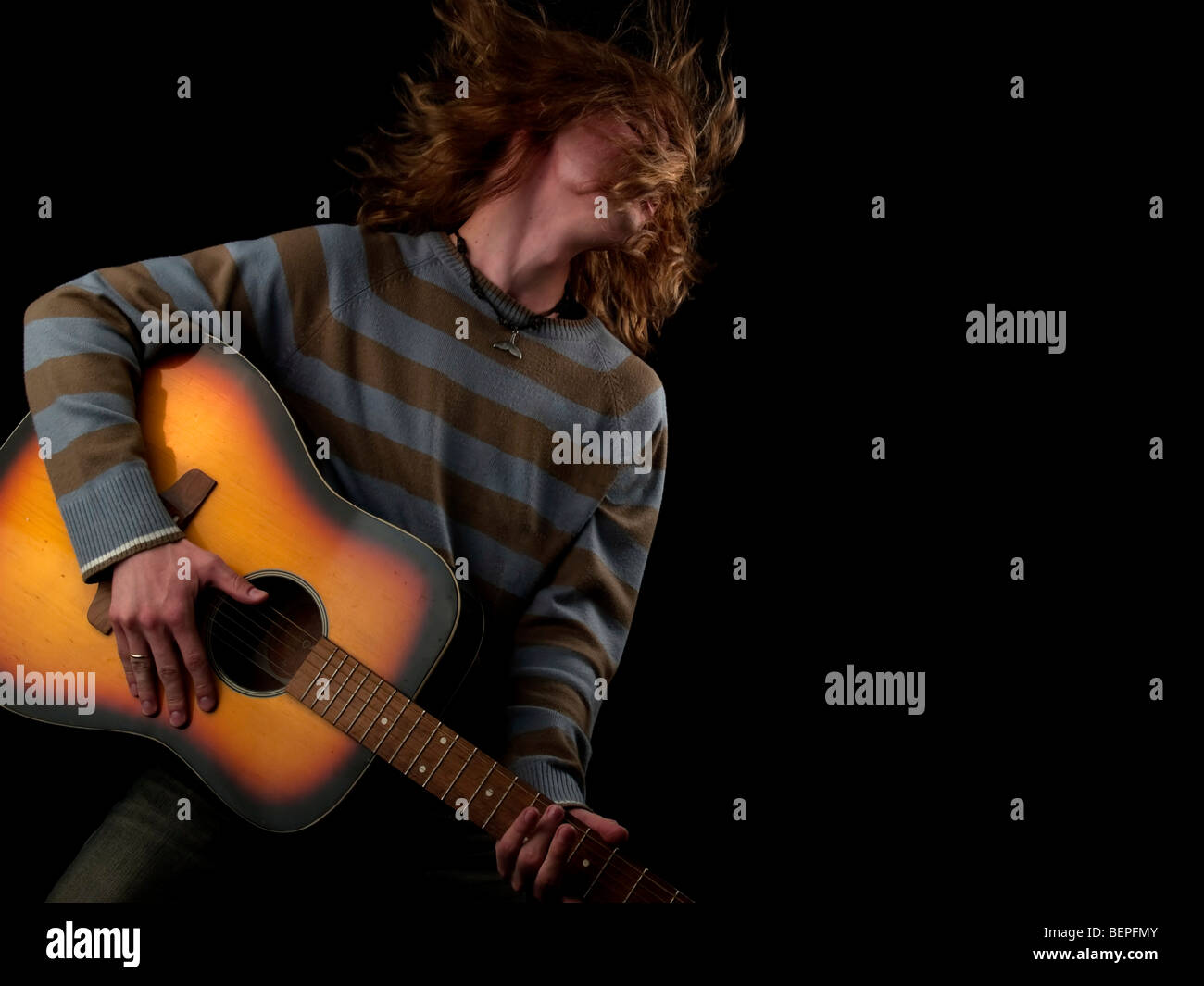 Les jeunes cheveux longs joue le guitariste hard rock Banque D'Images