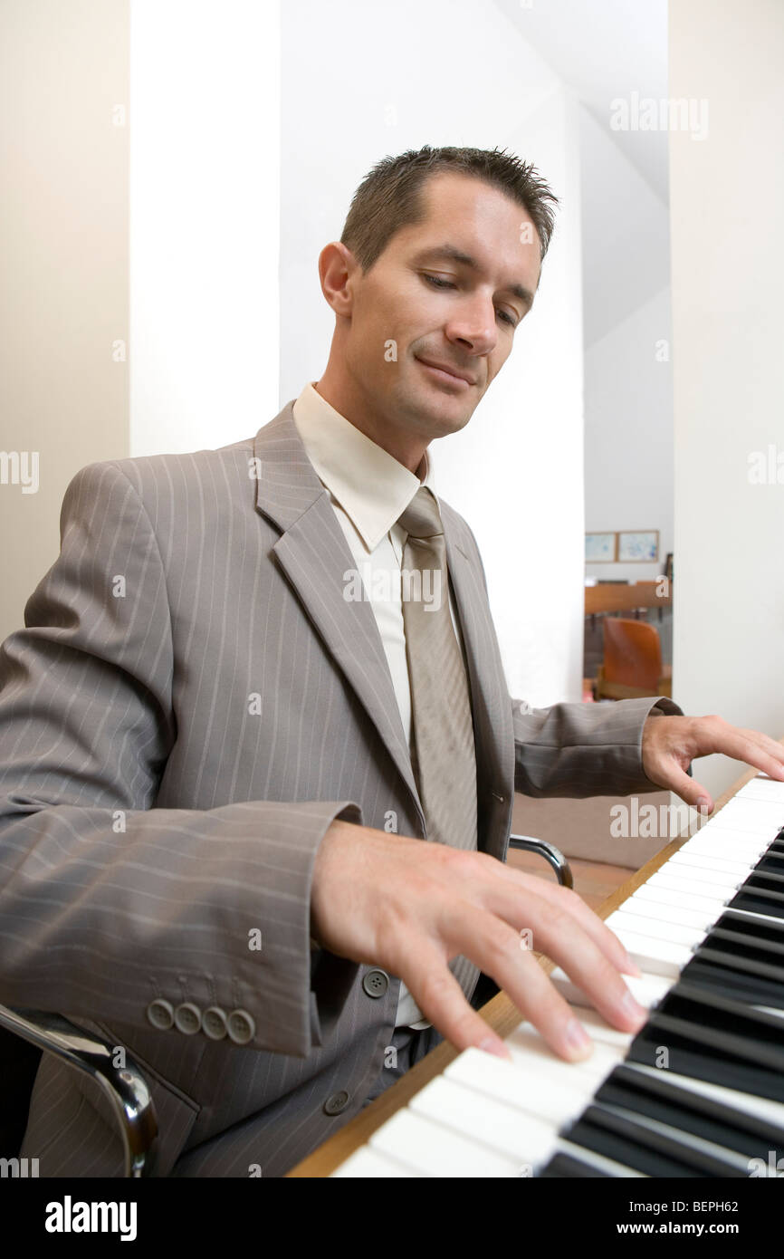 Businessman playing piano Banque D'Images