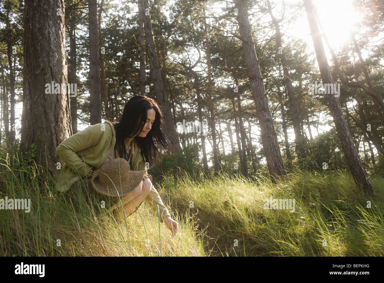 Woman crouching s'engager dans la nature Banque D'Images