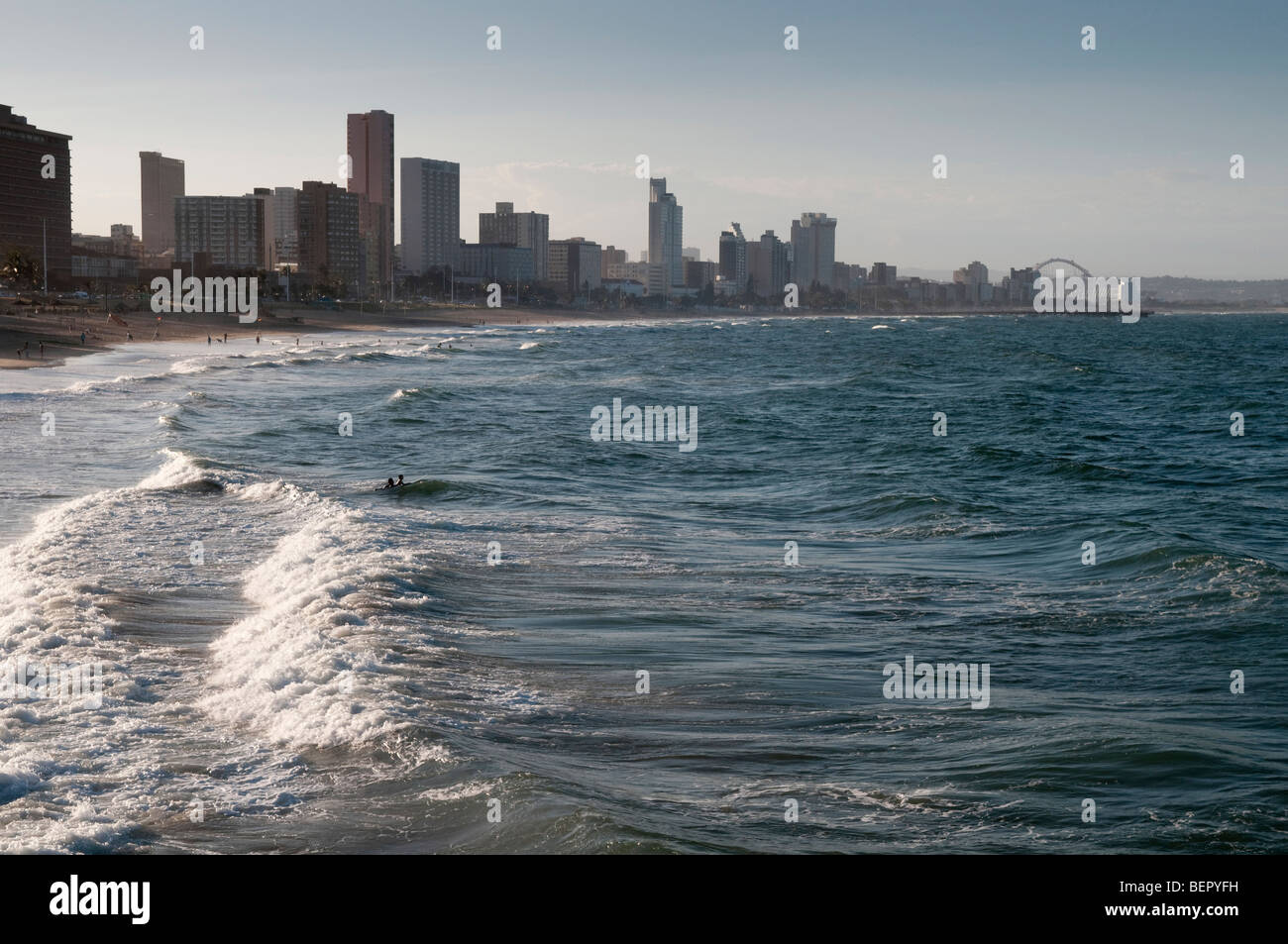 Les surfeurs sur la plage de Durban, Afrique du Sud le stade de football avec en arrière-plan Banque D'Images