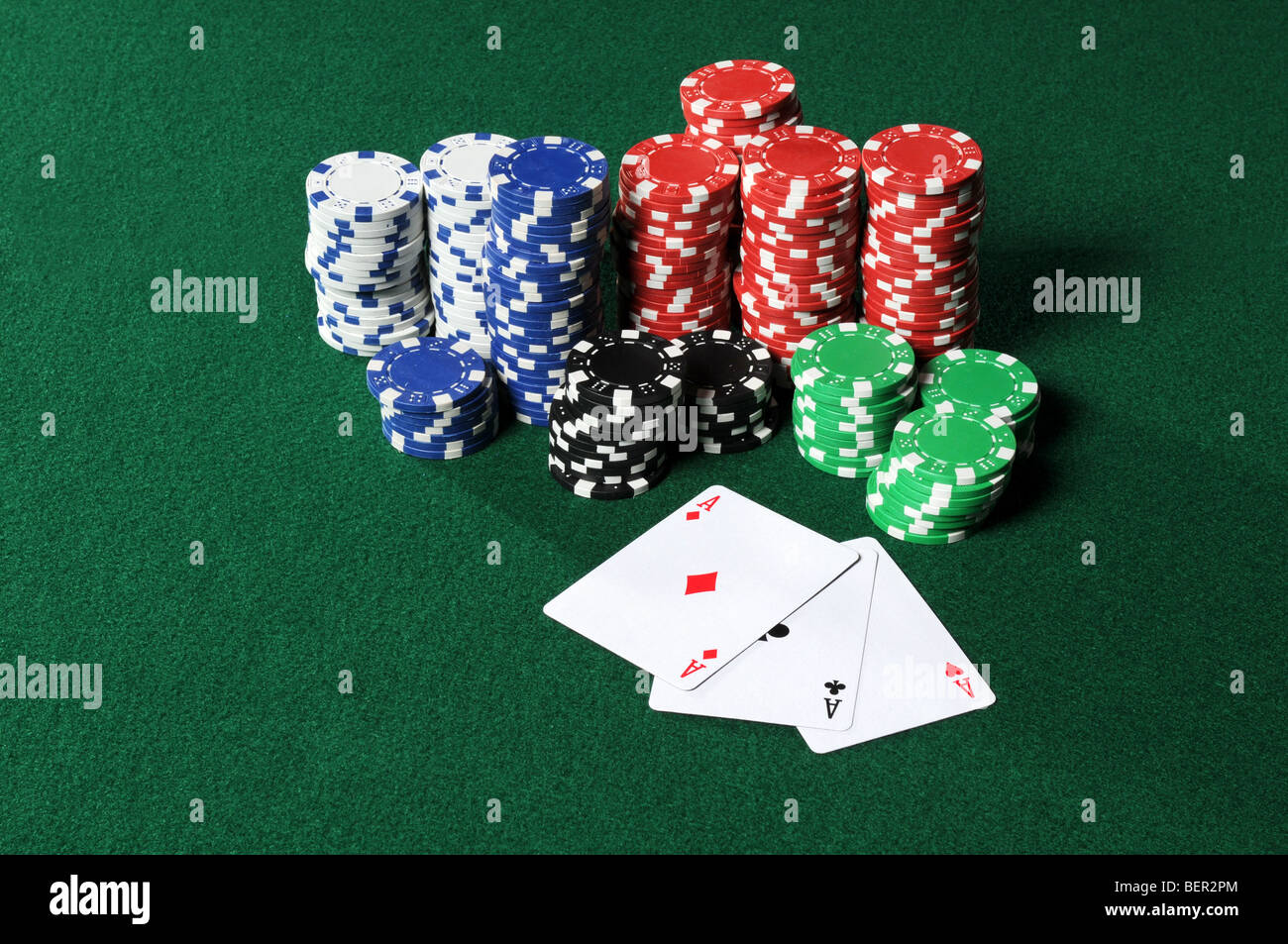 Quatre As et une pile de jetons de poker sur table verte Banque D'Images