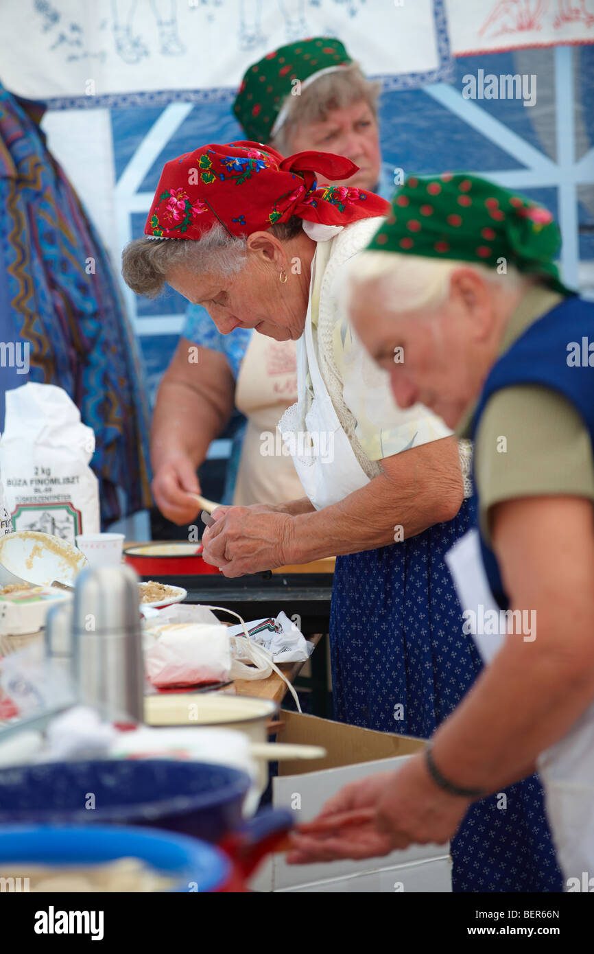 Les femmes de la région de l'Nagrecse hongrois en costume traditionnel dodolle cuisson- Hongrie Banque D'Images