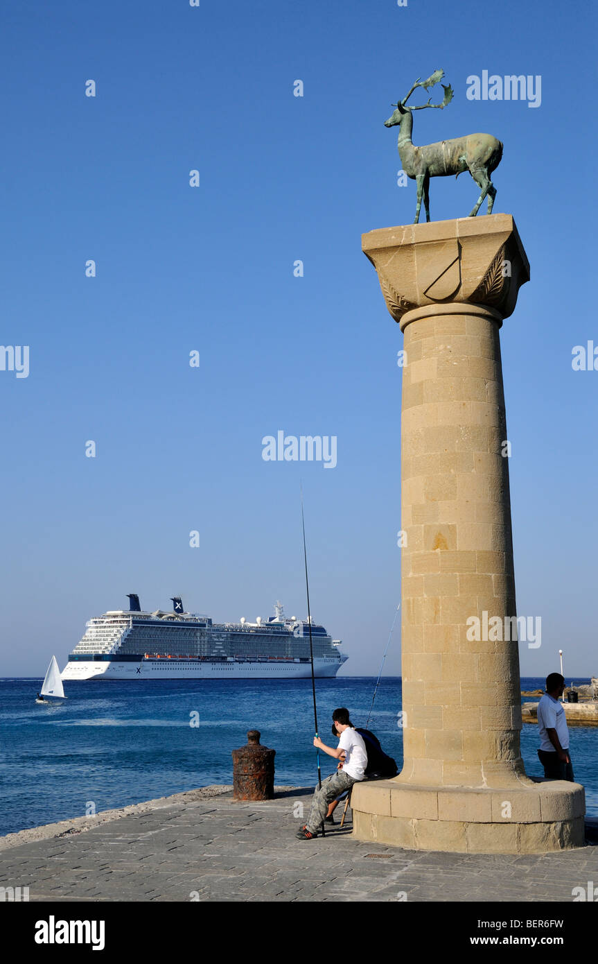La ville de Rhodes, Grèce, la pêche, les jeunes garçons à l'entrée de port de Mandraki en regardant grand navire de croisière. Banque D'Images