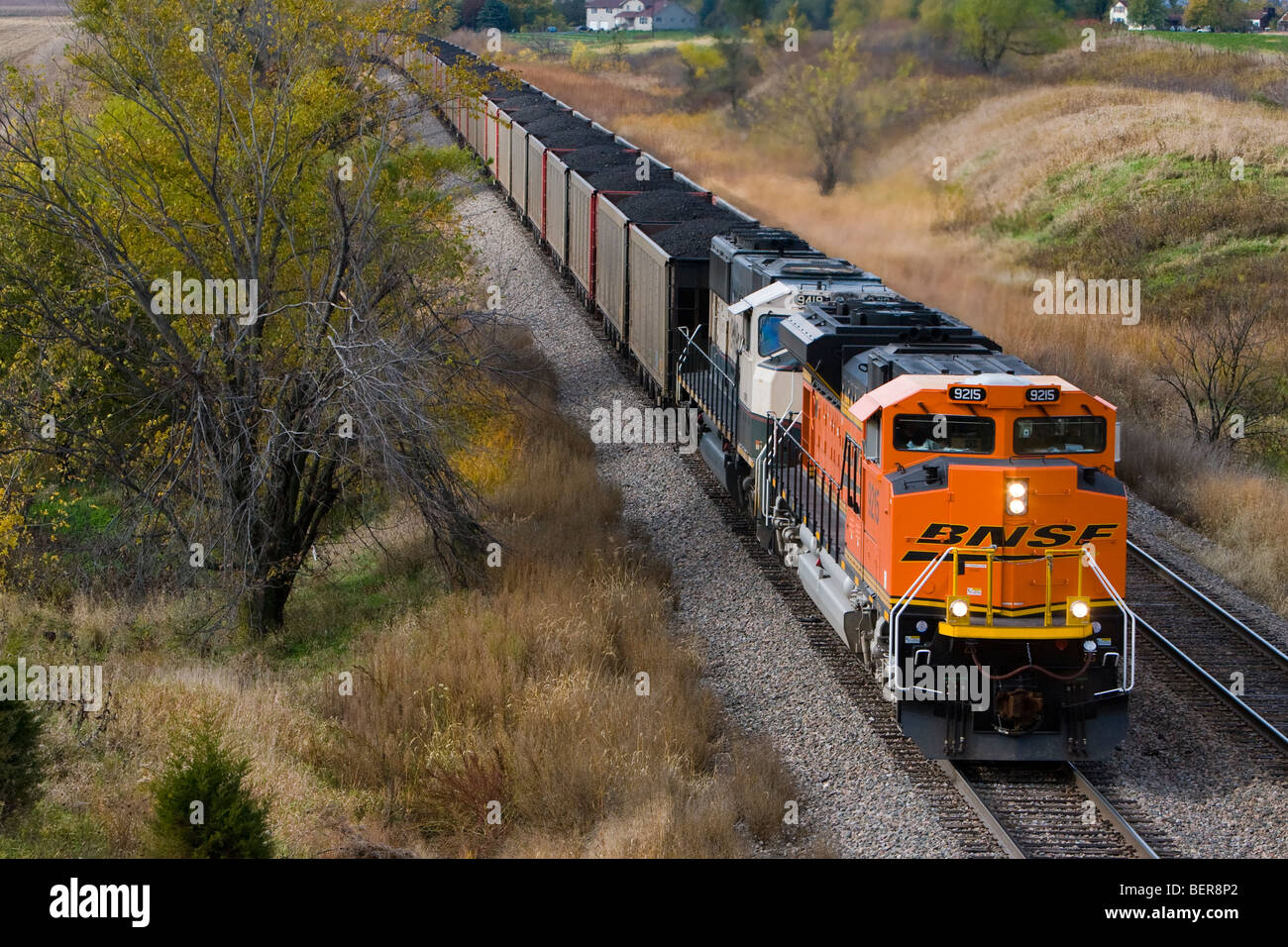 Un train de charbon par BNSF rouleaux centraux de l'Iowa, ce qui porte encore un autre chargement de charbon à faible teneur en soufre d'une centrale électrique. Banque D'Images
