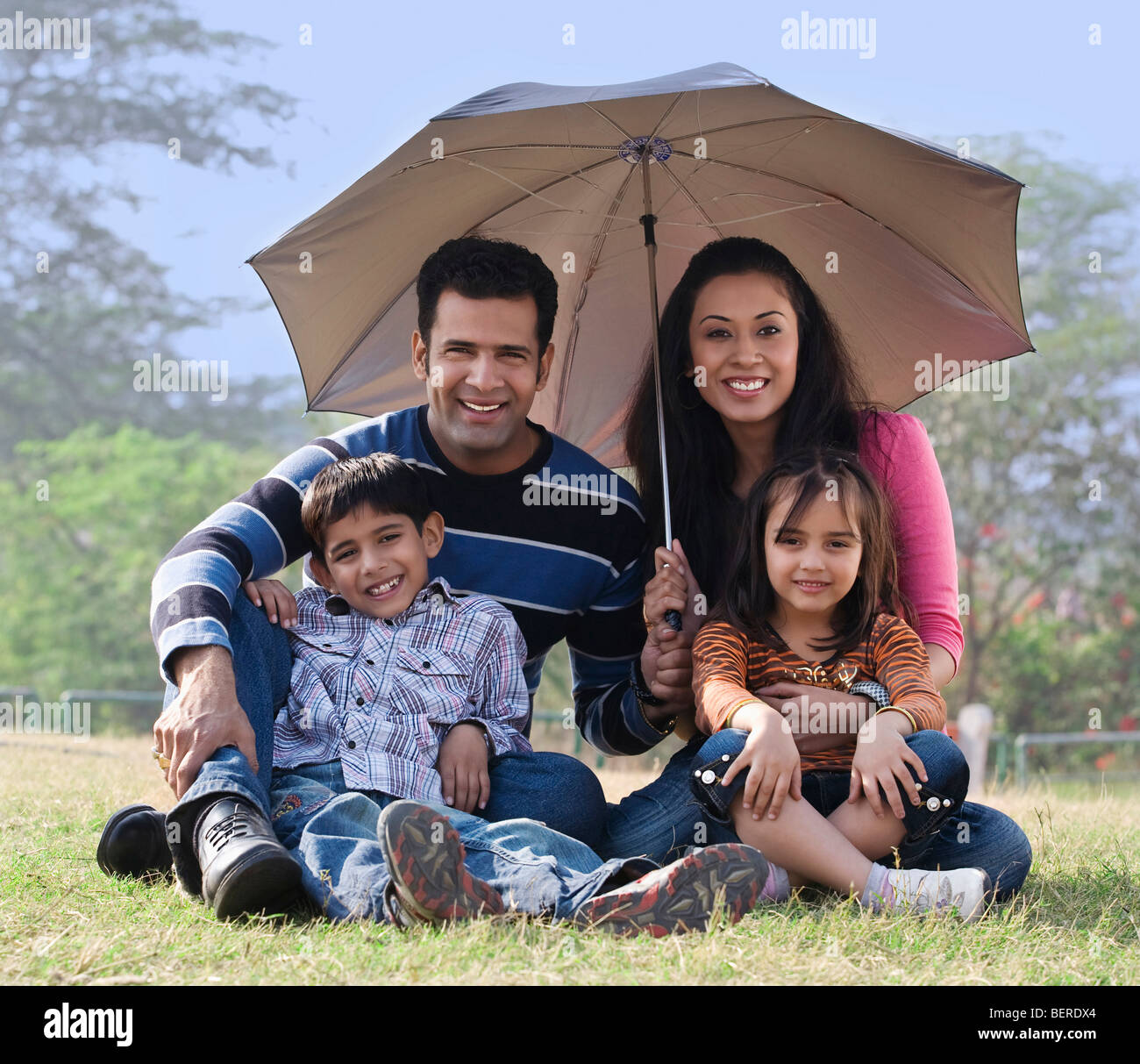 Famille posant avec un parapluie Banque D'Images