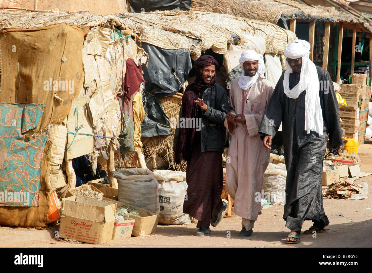 Trois Touaregs marchant dans la rue de la ville d'Agadez au Niger, Afrique de l'Ouest Banque D'Images