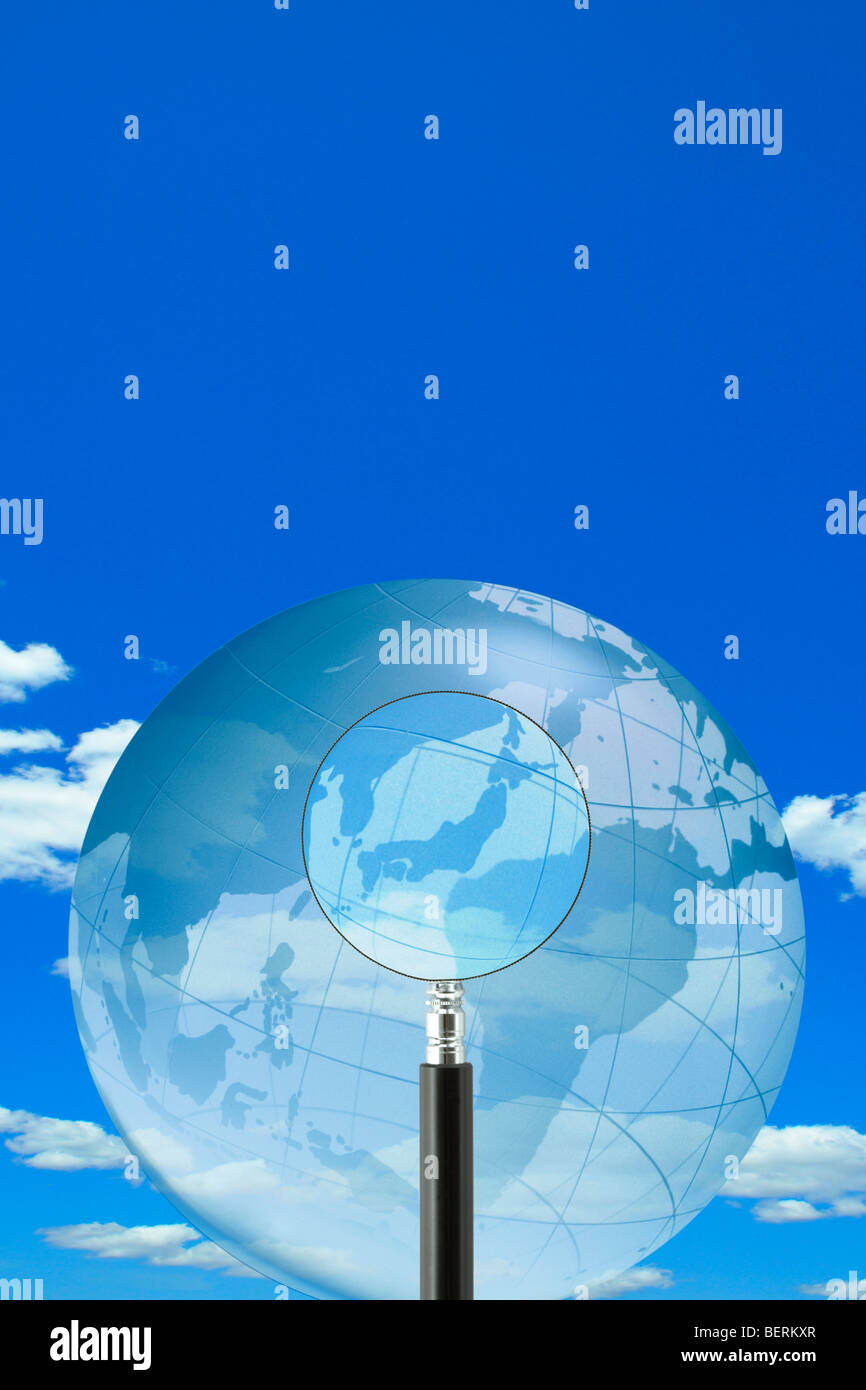 Magnifier et Globe dans le ciel bleu Banque D'Images