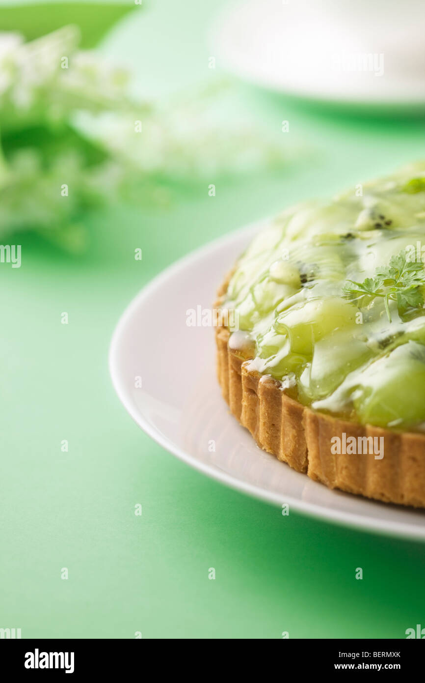 Tarte kiwi et raisin muscat sur la plaque, fond vert Banque D'Images