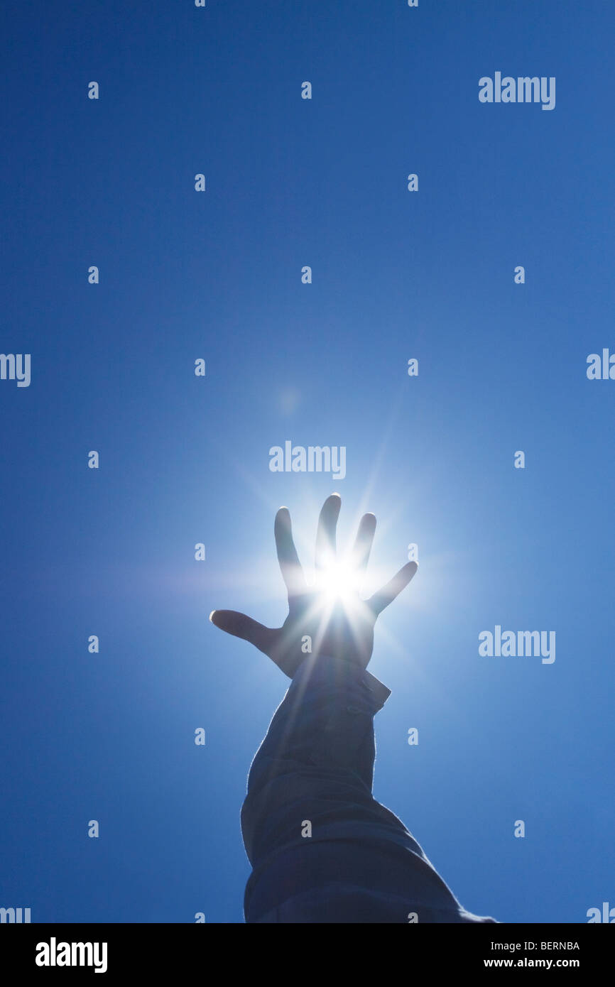 Woman's hand reaching sun Banque D'Images