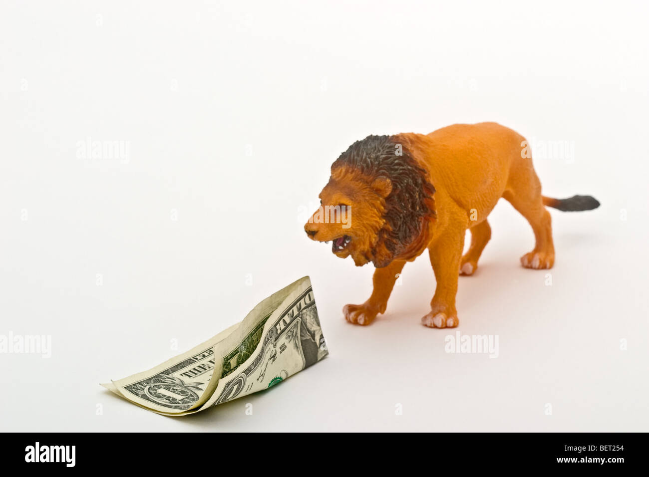 Lion jouet en plastique la fermeture sur une Amérique dollar bill Banque D'Images