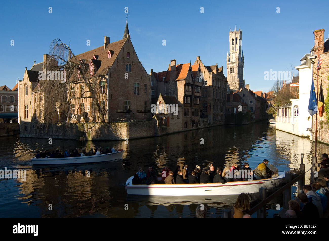 Beffroi et les touristes de prendre une excursion en bateau sur les canaux de Bruges, Flandre occidentale, Belgique Banque D'Images