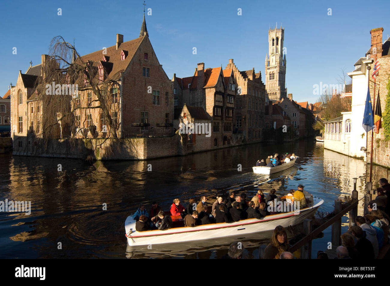Beffroi et les touristes de prendre une excursion en bateau sur les canaux de Bruges, Flandre occidentale, Belgique Banque D'Images