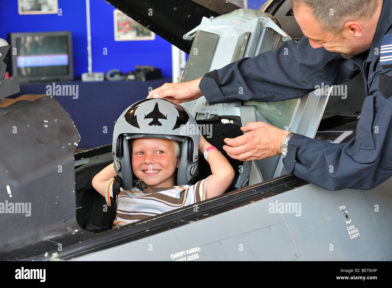 Dans le cockpit de l'enfant portant un casque de pilote de chasse à l'Airshow à Koksijde, Belgique Banque D'Images