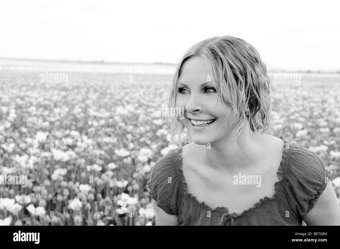 Belle Caucasian woman walking dans un champ de pavot blanc Banque D'Images
