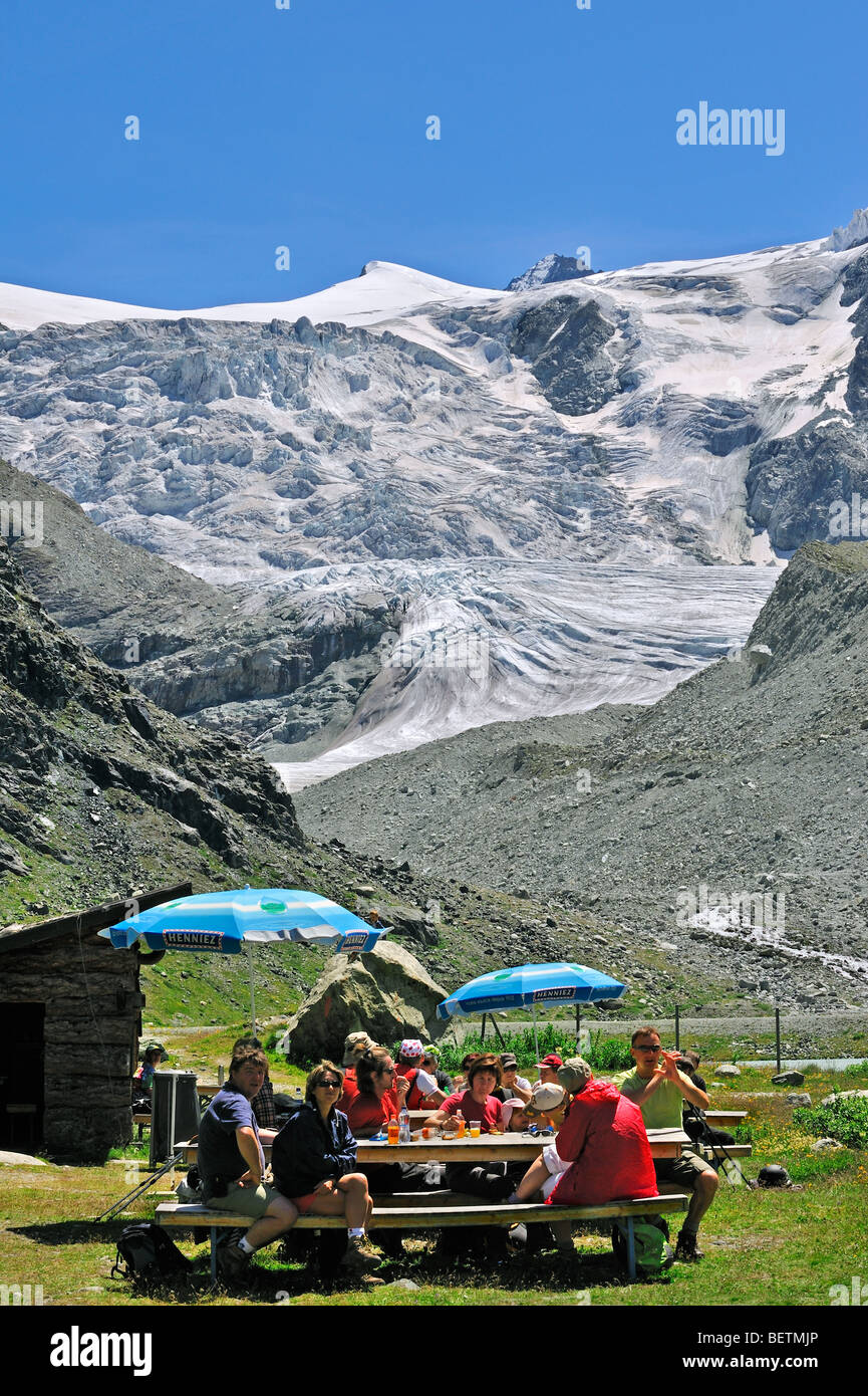 Les touristes se reposant devant le retrait du glacier de Moiry dans les Alpes Pennines / Walliser Alpen, Valais / Wallis (Suisse) Banque D'Images