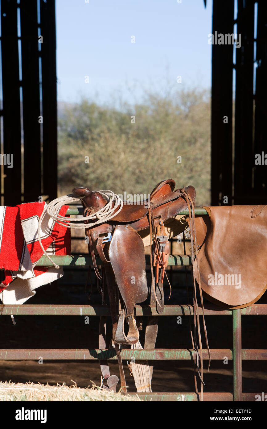 Selle de cheval, couverture, lariat les chaps et sont prêts à l'emploi à une grange. Banque D'Images