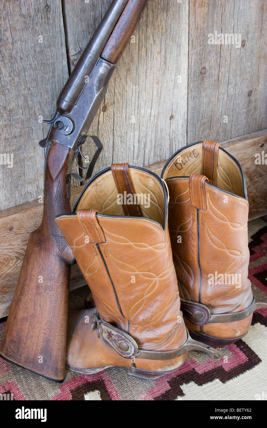 Cowboy & film l'acteur John Wayne's shotgun et bottes en cuir cowoby et eperons utilisé dans plusieurs de ses films de l'ouest. Banque D'Images