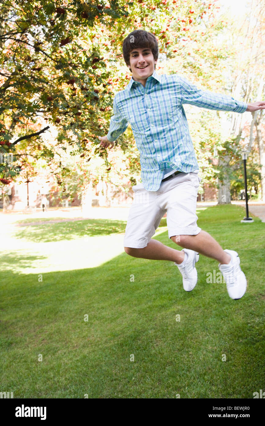 Teenage boy jumping in a park Banque D'Images