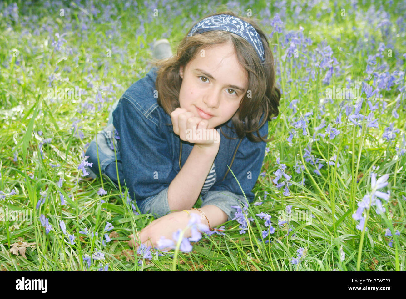 Enfant dans domaine de bluebells couché seul Banque D'Images