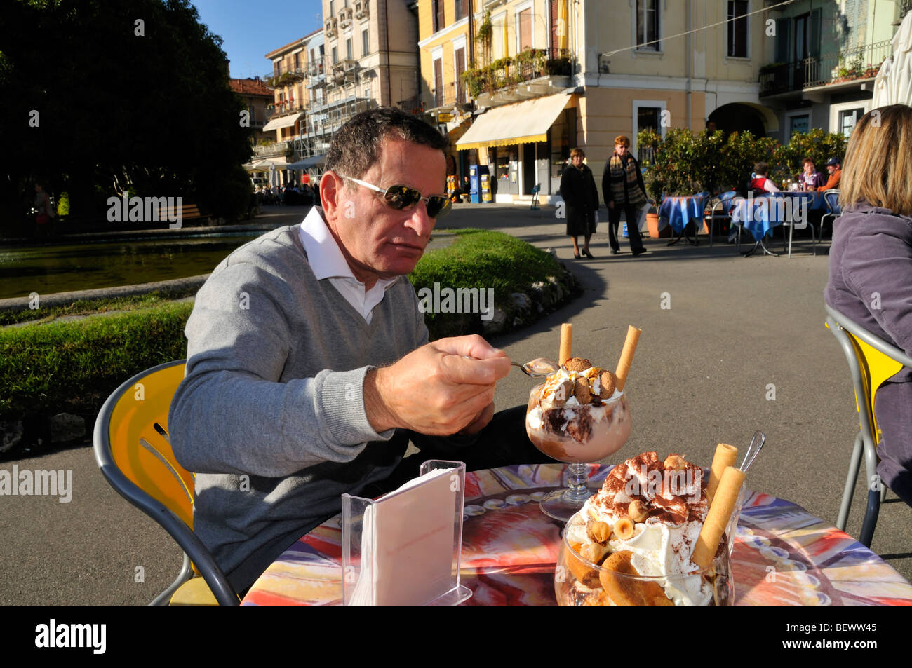 Un homme senior qui mange de la glace sur une terrasse de café, Lago Maggiore, Italie Banque D'Images