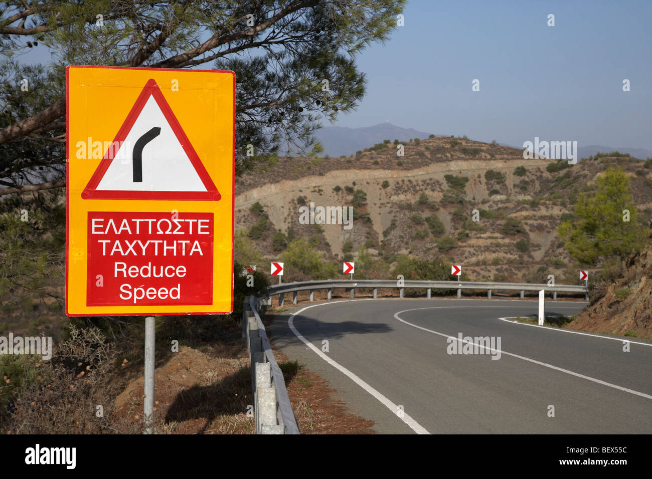 Réduire la vitesse bilingue virage dangereux signe sur l'f106 route près de montagne stavrovouni république de Chypre Europe Banque D'Images