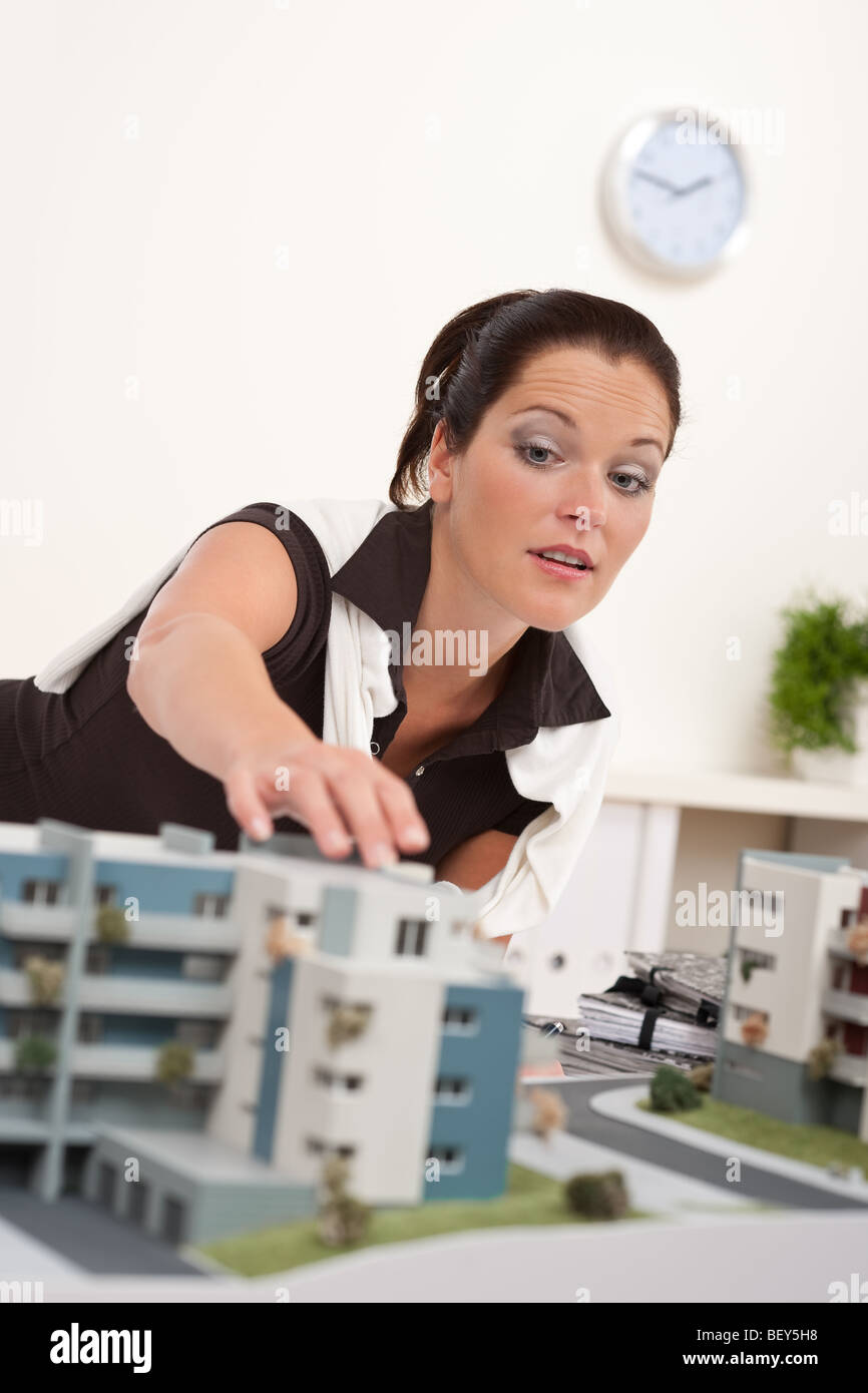 Jeune architecte avec modèle architectural au bureau de travail Banque D'Images