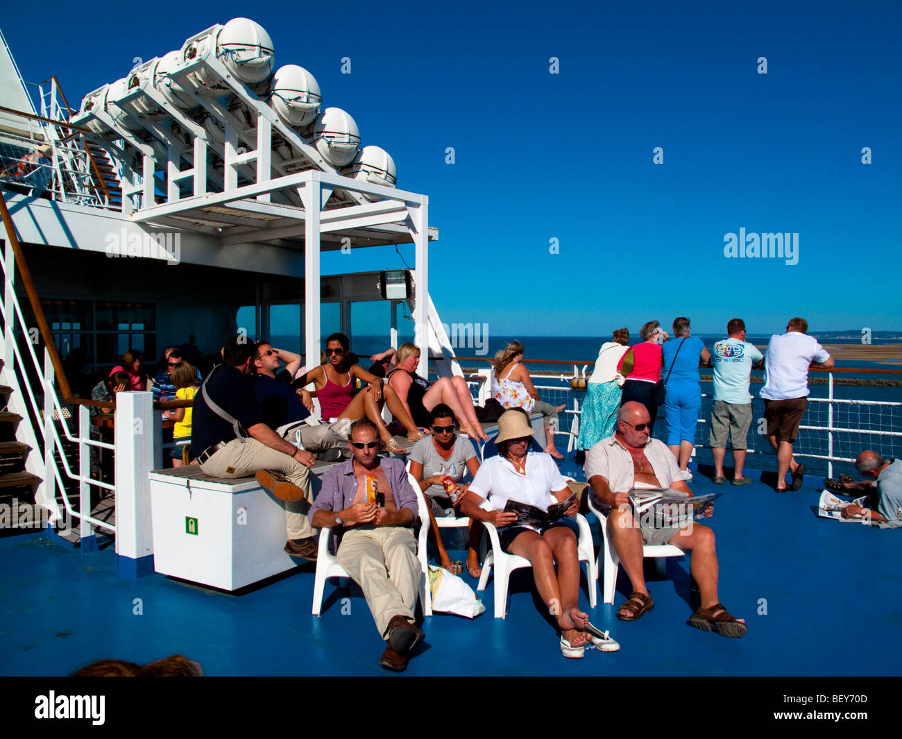 Les passagers se détendre sur un ferry Transmanche, assis au soleil Banque D'Images