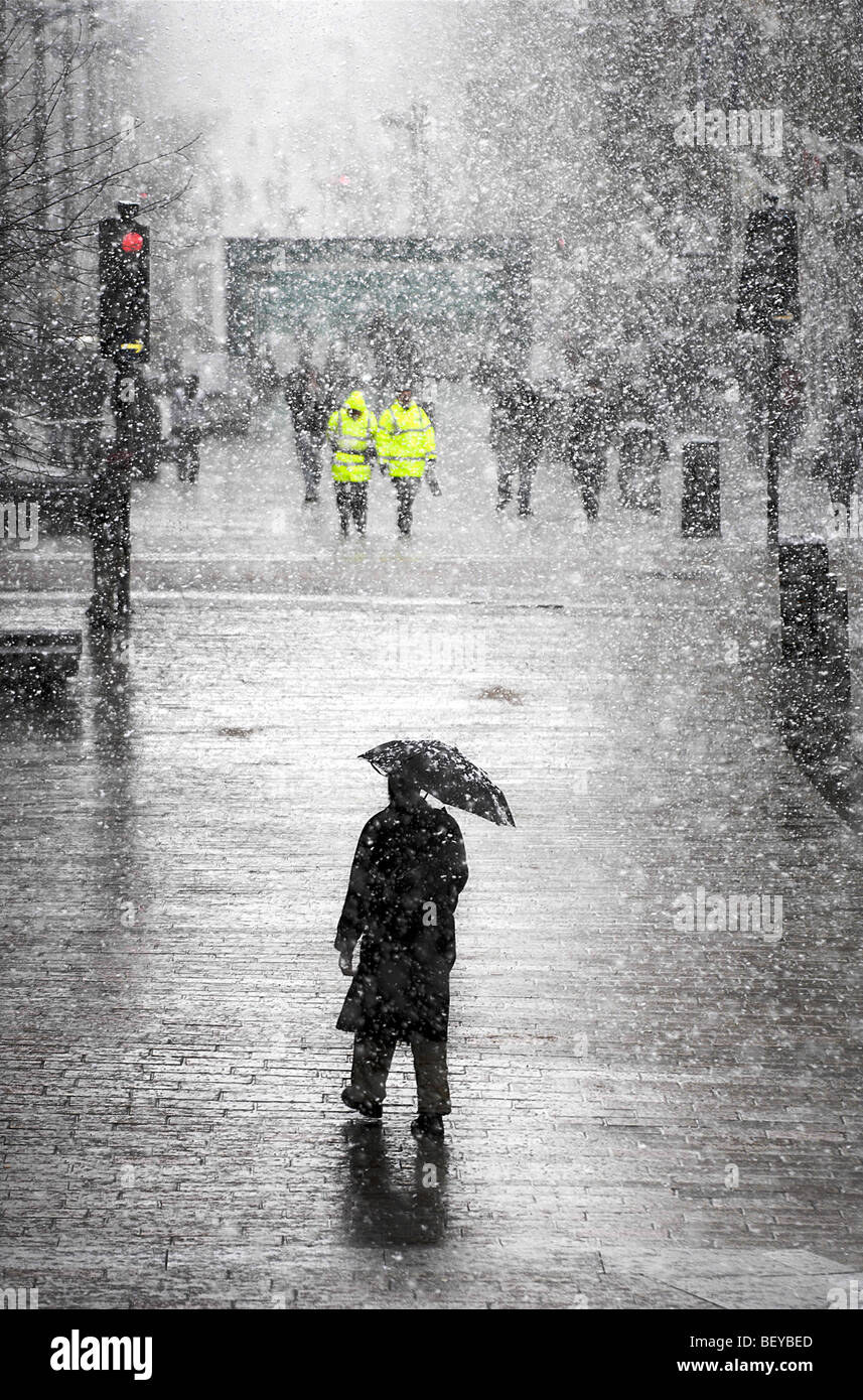 Un homme marche dans la neige sur Buchanan Street dans le centre de Glasgow, en Écosse. Banque D'Images